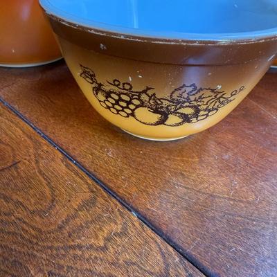 Sale Photo Thumbnail #166: This is for three Pyrex bowls. Two are orange and one is a cream, yellow type color with fruit marked on it.