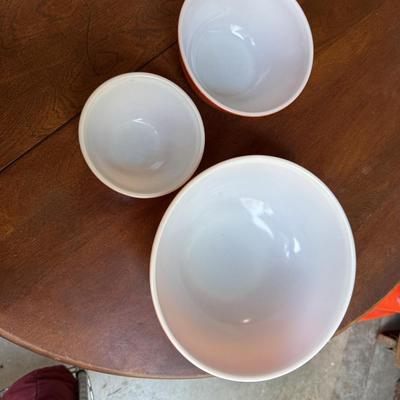 Sale Photo Thumbnail #164: This is for three Pyrex bowls. Two are orange and one is a cream, yellow type color with fruit marked on it.