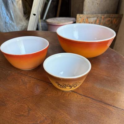 Sale Photo Thumbnail #163: This is for three Pyrex bowls. Two are orange and one is a cream, yellow type color with fruit marked on it.