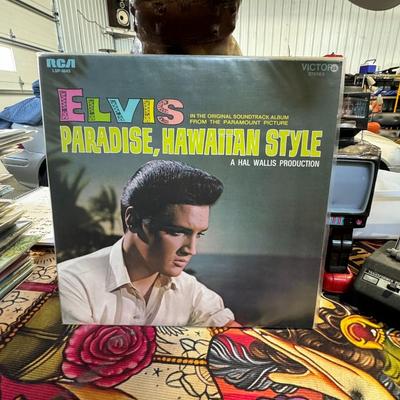 Sale Photo Thumbnail #200: Paradise, Hawaiian Style by Elvis Presley. 
Here are some details about the album:
Release Information: It is the thirteenth soundtrack album by Elvis Presley, released by RCA Victor in June 1966, available in both mono (LPM) and stereo (LSP) formats with