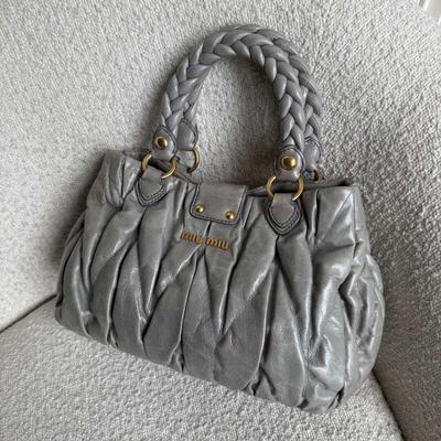 Sale Photo Thumbnail #17: Expertly crafted from grey leather with gold hardware, the Miu Miu Matelasse Grey Leather Handbag is the ultimate in luxury and style. The elegant design features a magnetic compartment and zip-up pocket, perfect for storing all your essentials. With a go