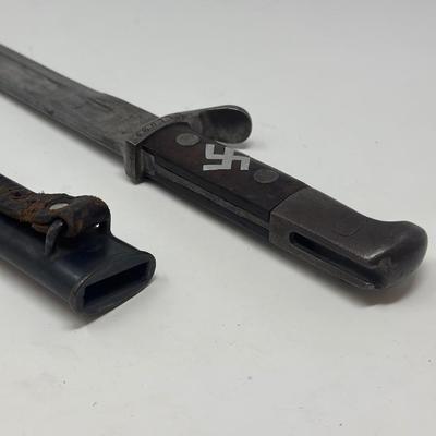 Sale Photo Thumbnail #81: Blade is 11 3/4” long and 17 1/2” long overall 
Waffenfabrik Neuhausen Bayonet. Stamped 460779. Inlaid metal swastika in wooden and metal hilt.