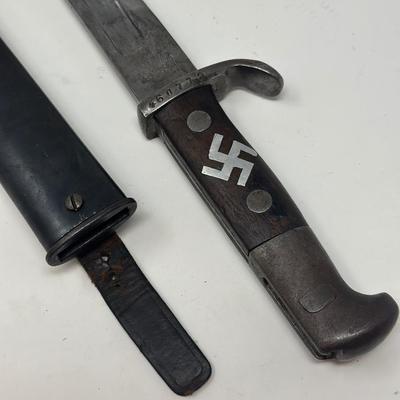 Sale Photo Thumbnail #76: Blade is 11 3/4” long and 17 1/2” long overall 
Waffenfabrik Neuhausen Bayonet. Stamped 460779. Inlaid metal swastika in wooden and metal hilt.