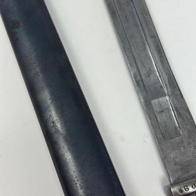 Sale Photo Thumbnail #78: Blade is 11 3/4” long and 17 1/2” long overall 
Waffenfabrik Neuhausen Bayonet. Stamped 460779. Inlaid metal swastika in wooden and metal hilt.