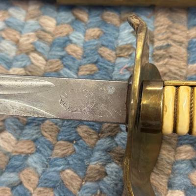 Sale Photo Thumbnail #122: This is an original World War II Kriegsmarine  (Nazi Navy) sword.  These weren’t used in combat but rather for parades and a symbol of status. The sword is maker stamped by E. F. Horster. The scabbard is damaged as shown in photos.
