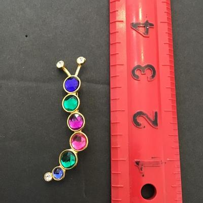 Sale Photo Thumbnail #119: Vintage gold tone, multi colored Caterpillar type brooch. Please see attached photos.