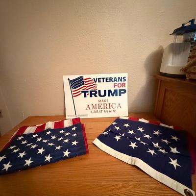 Two American flags and a Donald Trump poster