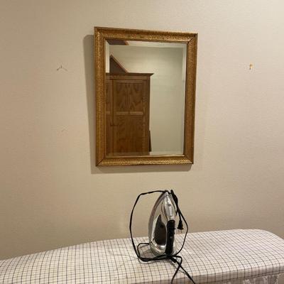 Iron, ironing board, and mirror with gold frame