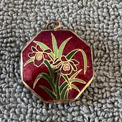 Beautiful octagonal pendant featuring a vibrant red enamel background with a floral design,