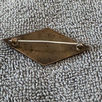 Rhombus-shaped pin featuring a hand-painted or transferred design of pink roses and green leaves on a light background