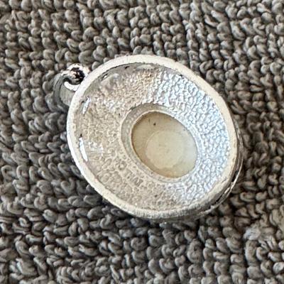 Sterling silver pendant featuring a mother of pearl cabochon surrounded by marcasite accents