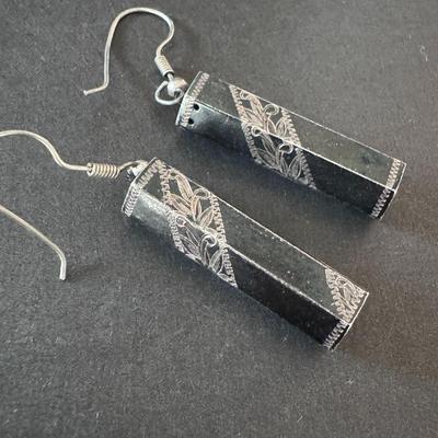 Elegant black rectangular dangle earrings with intricate silver-colored filigree or engraved designs.