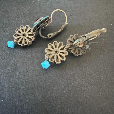 Pair of distinctive earrings, characterized by their striking combination of blue-green and red stones.