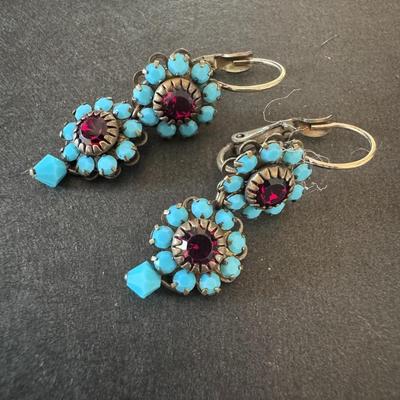 Pair of distinctive earrings, characterized by their striking combination of blue-green and red stones.