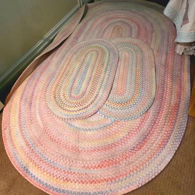 Sale Photo Thumbnail #65: 3 braided pastel oval rugs, the largest measuring 95.5"L x 58"W. The other 2 measuring the standard 2x3 door mat size. And 3 decorative wall hangings.