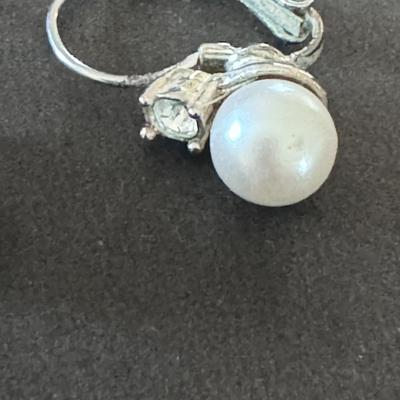 vintage-style clip-on earrings featuring white, round faux pearls set in a silver-tone metal.