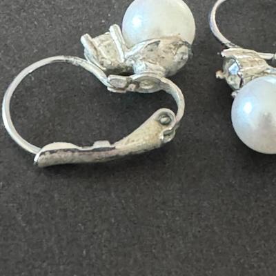 vintage-style clip-on earrings featuring white, round faux pearls set in a silver-tone metal.