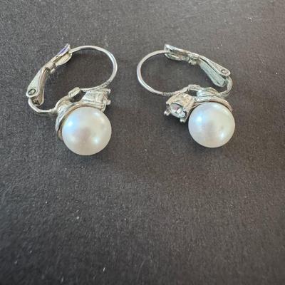 vintage-style clip-on earrings featuring white, round faux pearls set in a silver-tone metal.