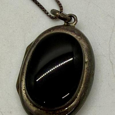 Sale Photo Thumbnail #162: 24" necklace chain. Cameo pendant opens to reveal 2 spaces for small oval photos. Oval stone looks to be made of onyx.