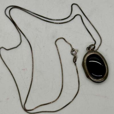 Sale Photo Thumbnail #168: 24" necklace chain. Cameo pendant opens to reveal 2 spaces for small oval photos. Oval stone looks to be made of onyx.