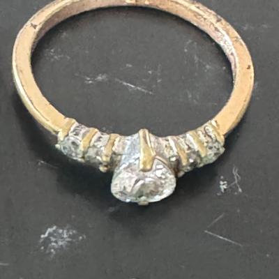 Two gold-toned rings, each featuring a prominent clear gemstone,