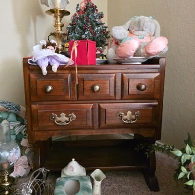 Early American nightstand with miscellaneous decor, florals, baskets and hanging corner wall shelf.