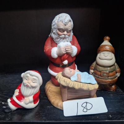 Santa praying over Baby Jesus and other santas
