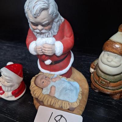 Santa praying over Baby Jesus and other santas