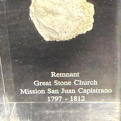 Sale Photo Thumbnail #452: Small pebble-sized wall fragment of the San Juan Capistrano Mission Church, sealed in a clear Lucite display.