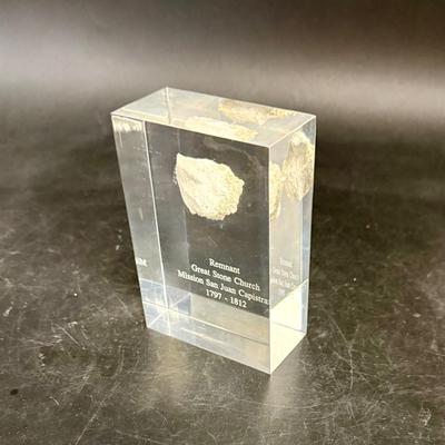 Sale Photo Thumbnail #453: Small pebble-sized wall fragment of the San Juan Capistrano Mission Church, sealed in a clear Lucite display.