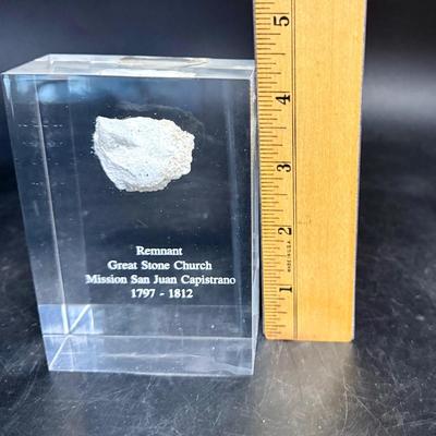 Sale Photo Thumbnail #454: Small pebble-sized wall fragment of the San Juan Capistrano Mission Church, sealed in a clear Lucite display.