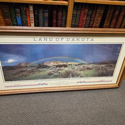 Sale Photo Thumbnail #1: This is a larger print.  Called Land of Dakota is professionally framed, signed and numbered.  Is a great piece of North Dakota history. This celebrates 100 of ND statehood.  Has certificate and information about the piece.  Painted in 1983 this is 57 of 