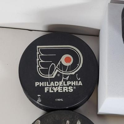 LOT 93: Many Autographed Hockey Pucks by Various Players from Philadelphia Flyers, New Jersey Devils and More