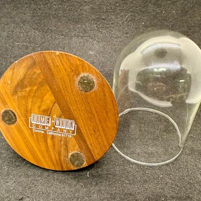Sale Photo Thumbnail #570: Round wooden base with a brass post with hook, to display a pocket watch, handing ornament, or mother item,  Clear glass dome cover, which is removable. Good condition, approx. 5" tall overall.