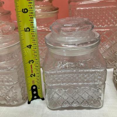 Sale Photo Thumbnail #18: 9 glass canisters with lids. See pictures for approx measurements. No chips/cracks.