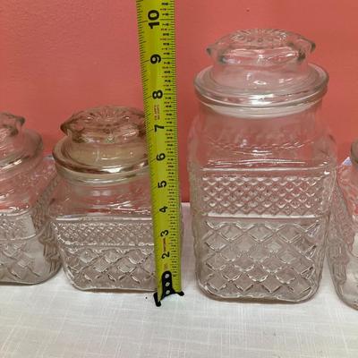 Sale Photo Thumbnail #16: 9 glass canisters with lids. See pictures for approx measurements. No chips/cracks.
