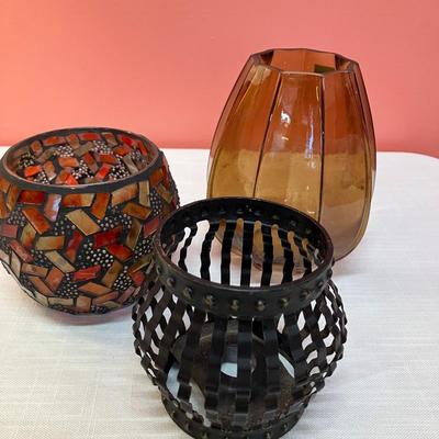 Sale Photo Thumbnail #61: Collection of 3 votive round candle holders. 1 red/amber glass, 1 amber glass, 1 black metal.