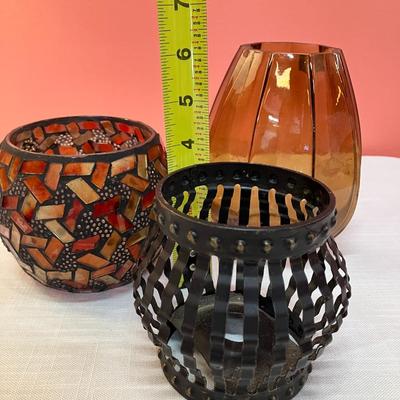 Sale Photo Thumbnail #62: Collection of 3 votive round candle holders. 1 red/amber glass, 1 amber glass, 1 black metal.