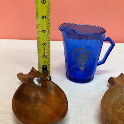 Sale Photo Thumbnail #223: Set of 2 small wooden pineapple bowls and a blue glass cream pitcher with a white etched image of Shirley Temple