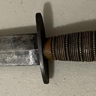 Sale Photo Thumbnail #217: The blade shows signs of age and possible wear. There are  metal bands wrapped around the handle with spaced dots which adds both texture and reinforcement, suggesting it was made with function in mind. Please see photos for more details.