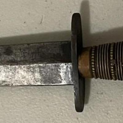 Sale Photo Thumbnail #220: The blade shows signs of age and possible wear. There are  metal bands wrapped around the handle with spaced dots which adds both texture and reinforcement, suggesting it was made with function in mind. Please see photos for more details.