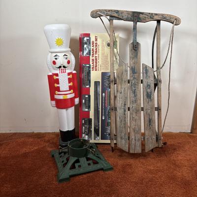 LOT 94: Vintage Wooden Childs Sled, Nutcracker Blow Mold (no light), Cast Iron Tree Stand and Lemax Village Train System