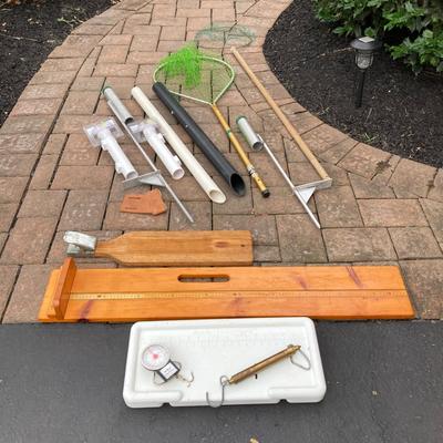 LOT 119: Fishing Nets, Fishing Pole Holders, Fish Filleting Boards, and Scales