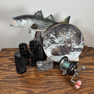 LOT 142: Outdoor Life Collection: Made in USA Belt Buckle, Danbury Mint Collectors Plate, Binoculars, Fishing Reel & Resin Striped Bass
