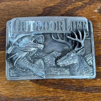 LOT 142: Outdoor Life Collection: Made in USA Belt Buckle, Danbury Mint Collectors Plate, Binoculars, Fishing Reel & Resin Striped Bass