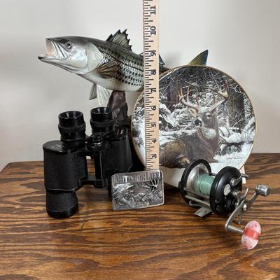 LOT 142: Outdoor Life Collection: Made in USA Belt Buckle, Danbury Mint Collectors Plate, Binoculars, Fishing Reel & Resin Striped Bass