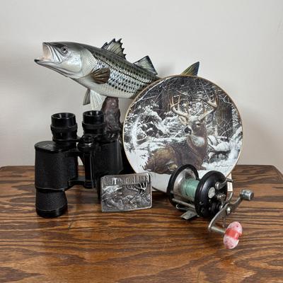 LOT 142: Outdoor Life Collection: Made in USA Belt Buckle, Danbury Mint Collectors Plate, Binoculars, Fishing Reel & Resin Striped Bass