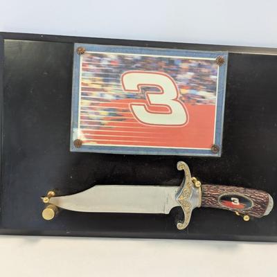 Sale Photo Thumbnail #1169: The product is a NASCAR Dale Earnhardt #3 The Intimidator Bowie Knife with Plaque, paying tribute to the legendary auto racing driver. Featuring a plaque with the image and name of Dale Earnhardt, this unique item is perfect for fans of NASCAR and auto ra