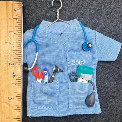 Sale Photo Thumbnail #491: Size of the coat is similar to Barbi clothes. Copat is on a hanger, with a stethoscope, scissors, thermometer, blood pressure cuff and otoscope. 30 service pins are for San Gabriel Valley medical center.