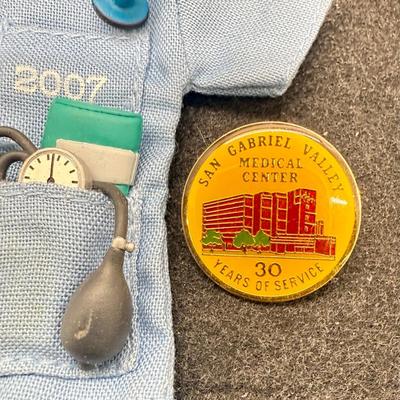 Sale Photo Thumbnail #489: Size of the coat is similar to Barbi clothes. Copat is on a hanger, with a stethoscope, scissors, thermometer, blood pressure cuff and otoscope. 30 service pins are for San Gabriel Valley medical center.